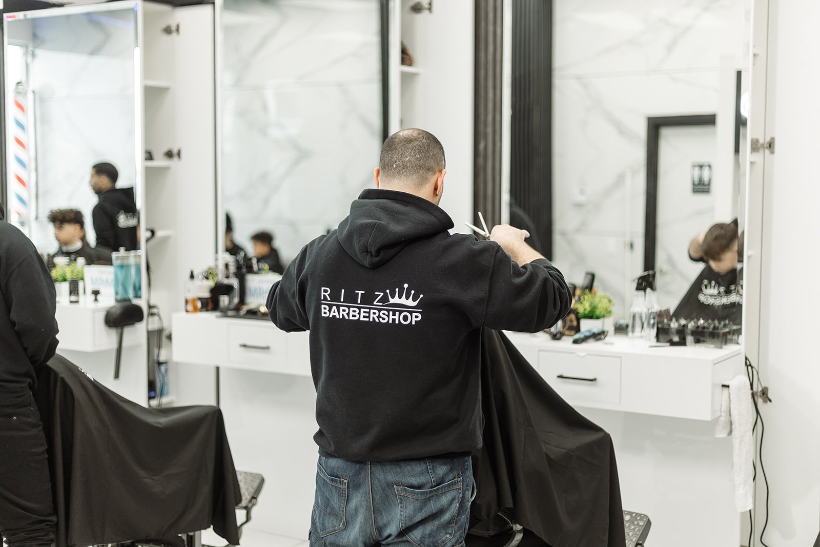 Barber detailing hairline with trimmer
