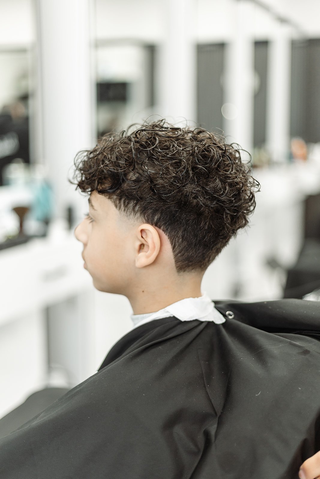 Barber showing client finished cut in hand mirror