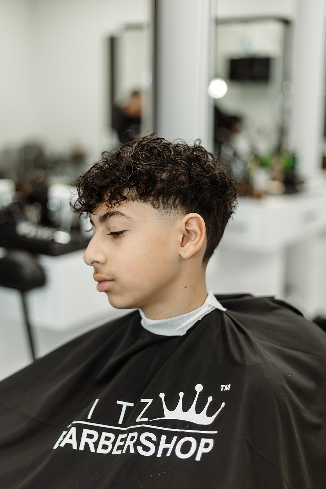 Client admiring skin fade in hand mirror